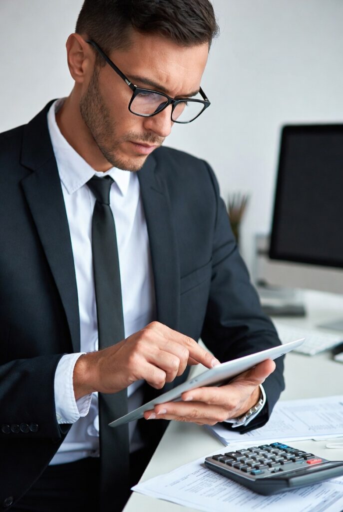 En välklädd man som använder en surfplatta för att deklarera digitalt 2026.